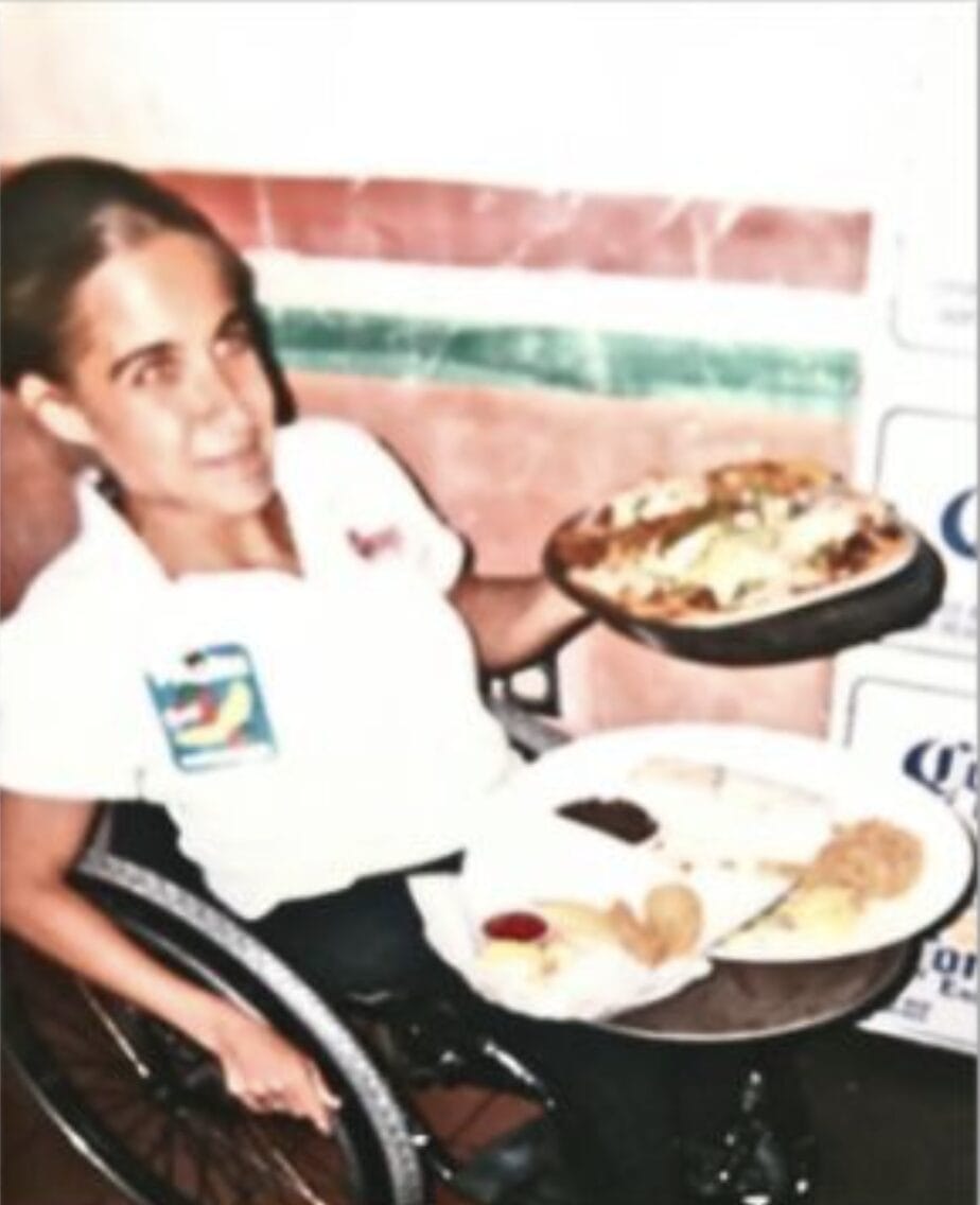 Alycia pushing wheelchair as a waitress in a wheelchair working